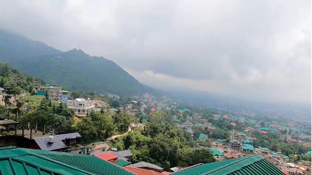 palampur town covered with thick clouds and forest of dhauladhar range