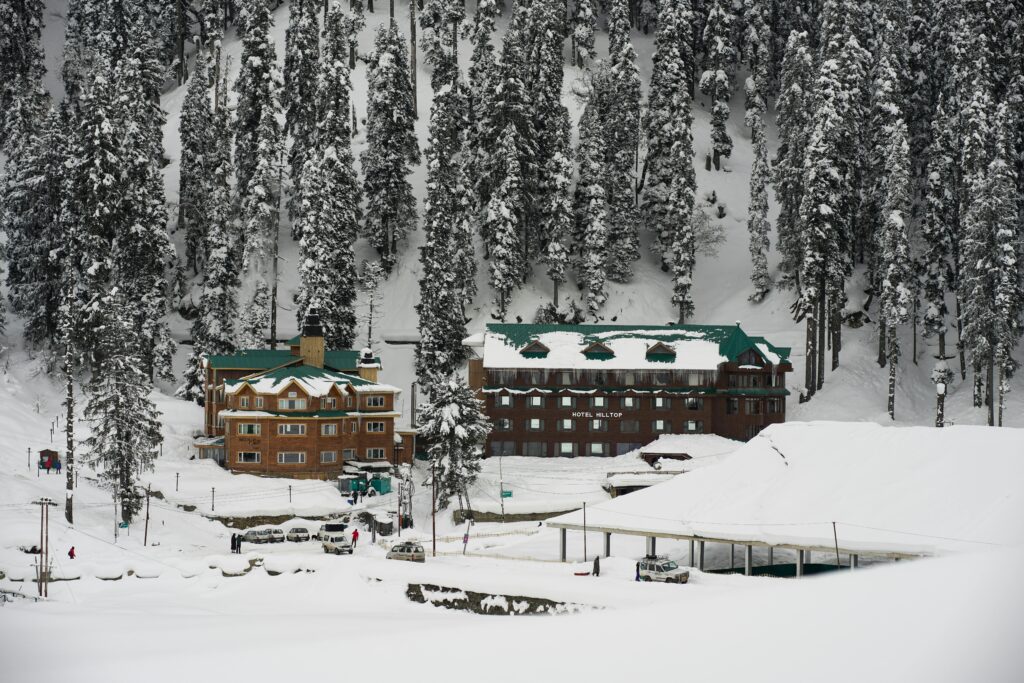 Gulmarg snow covered Hotel A picturesque view of snow-covered Hotel Hilltop in the serene winter landscape of Gulmarg, Kashmir. Gulmarg: Complete Travel Guide