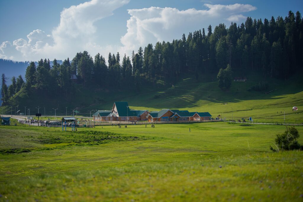 Gulmarg meadows Tranquil landscape with a modern hotel nestled in a verdant valley surrounded by lush hills. Gulmarg: Complete Travel Guide