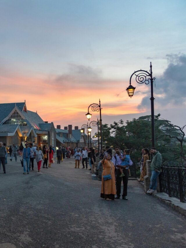 Evening scene with people near Indian landmark during sunset.