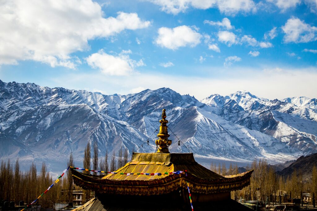 pexels-photo-879444-879444 Stunning landscape of Leh's mountain range and traditional temple roof under a blue sky.